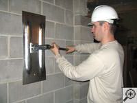 Attempting to straighten a bowed foundation wall by straightening a wall anchor system in a Pikeville home.