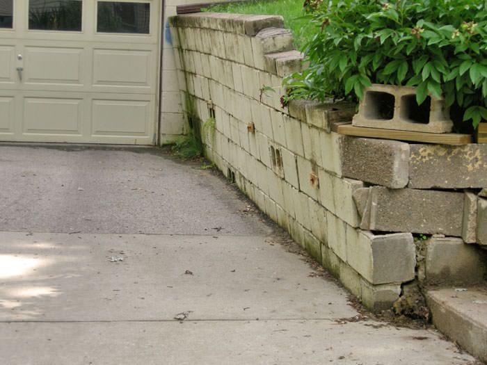 a failing retaining wall around a driveway in Saint Albans