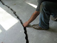 a severely damaged cracked concrete slab floor in Elkview