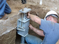 Foundation repair contractors installing the foundation bracket in Huntington.