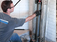 Driving foundation piers into the floor in Hurricane.