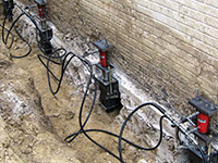 Using foundation push piers to lift a foundation during a repair in Ironton.
