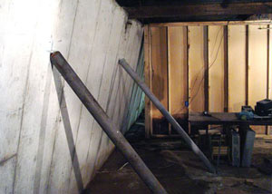 A severely tilting foundation wall propped up by steel beams in Wellston.