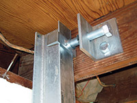 Securing the i-beam system to the top of the floor joist in a foundation wall repair in Pikeville.