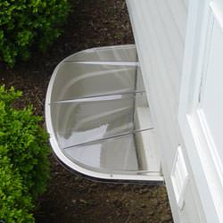 A vinyl basement window and covered window well in Dunbar