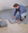 Contractors installing basement subfloor tiles and matting on a concrete basement floor in Portsmouth, West Virginia, Kentucky, Ohio